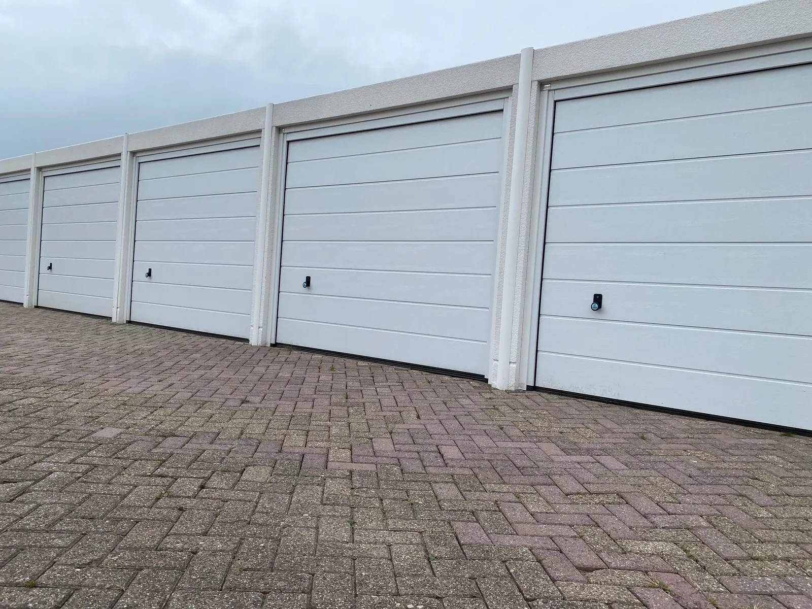 Rij nieuwe witte garageboxen met slimme sloten